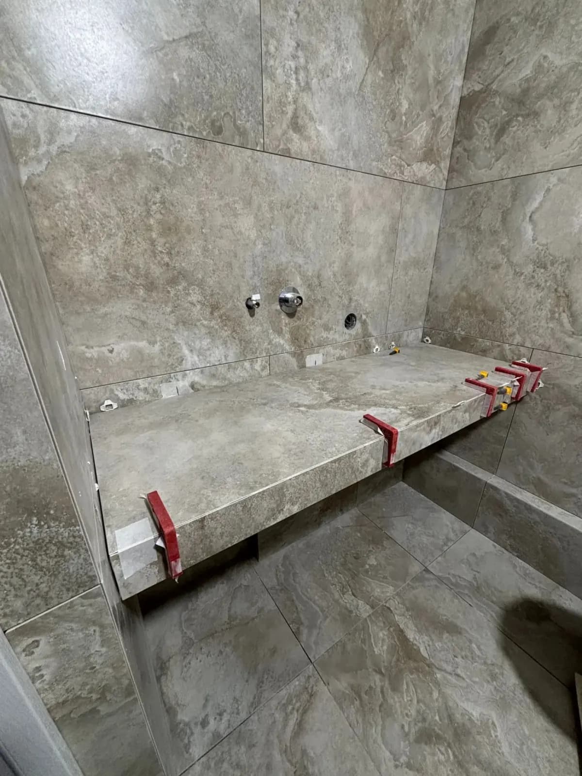 Graues Bad mit Mosaik, Wanne und integrierter Ablage Ansicht 3